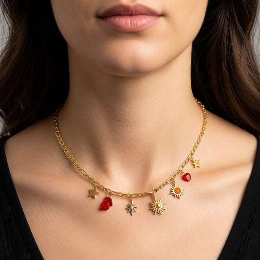 Aramat Jewels gold-tone stainless steel necklace with figaro chain and multiple charms including a red heart, sun, star, and red stone.