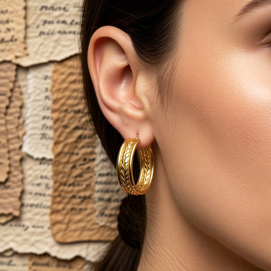 Aramat Jewels gold-coloured oval hoop earrings with a gourmet link pattern, made of stainless steel.