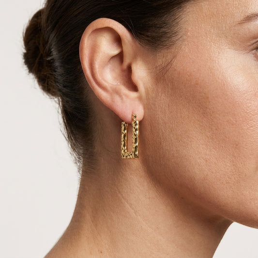 Aramat Jewels gold rectangular hoop earrings with a textured stripe pattern, 26x18mm, worn by a model.