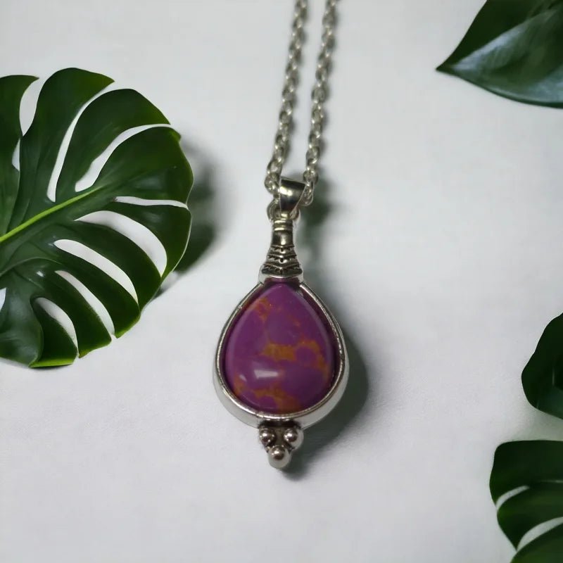 Een paarse stenen hanger met een zilveren ketting