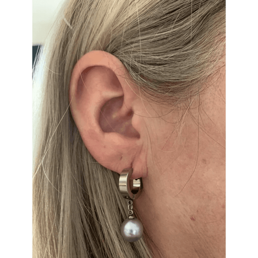 Een vrouw met blond haar en een paar oorbellen