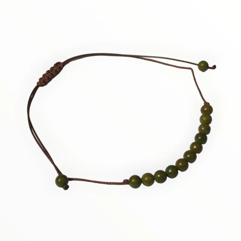 Een armband met groene kralen en een bruin koord