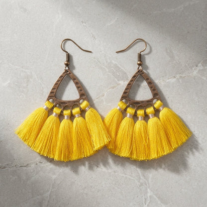 Aramat Jewels boho oorhangers met gele kwastjes en bronskleurig metalen frame, perfect voor een zomerse festivalstijl.
