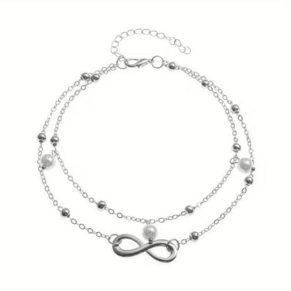 Aramat Jewels dubbel enkelbandje in zilverkleur met infinity symbool en delicate parels voor een zomerse look.