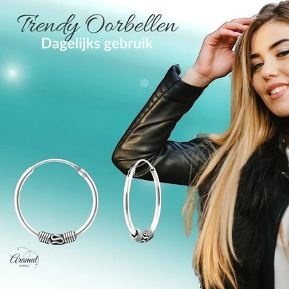 Aramat Jewels geoxideerde 925 zilveren Bali oorringen van 18mm met een boho festival design gedragen door een model