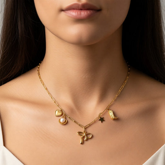 Aramat Jewels gold-tone stainless steel necklace with playful charms: heart, pearl, bow, star, and cowboy boot. 45+5 cm adjustable length.