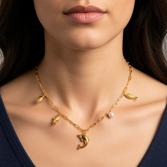 Aramat Jewels gold-tone stainless steel necklace with sea-themed charms: dolphin, fish, turtle, and a pearl. 45 cm length.