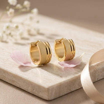Aramat Jewels gold-tone stainless steel huggie hoop earrings with sandblasted and shiny stripes, 13x7mm.