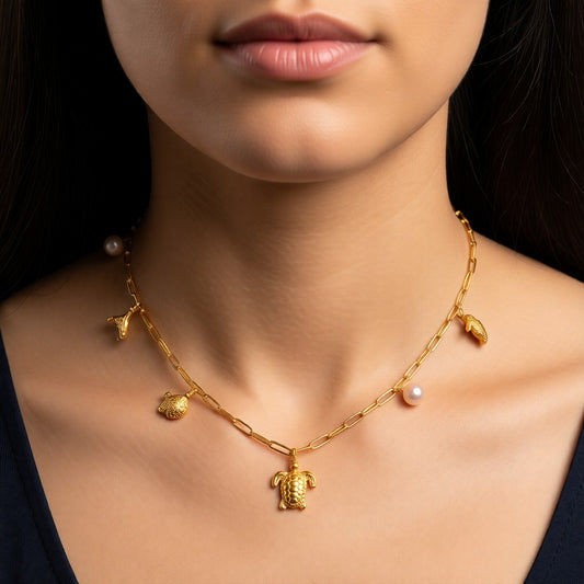 Aramat Jewels gold-tone stainless steel necklace with pearl and sea creature charms: turtle, seahorse, fish, and tail fin. 45 cm.