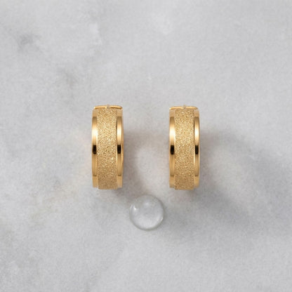 Aramat Jewels gold-tone stainless steel hoop earrings with sandblasted texture, 13mm or 20mm diameter.