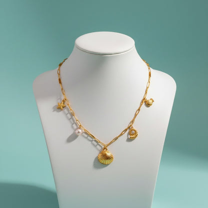 Aramat Jewels gold-tone link chain necklace with pearl and sea-themed charms: starfish, shell, snail, and turtle.
