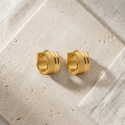 Aramat Jewels gold-tone stainless steel huggie hoop earrings with sandblasted and glossy stripes, 13x7mm.