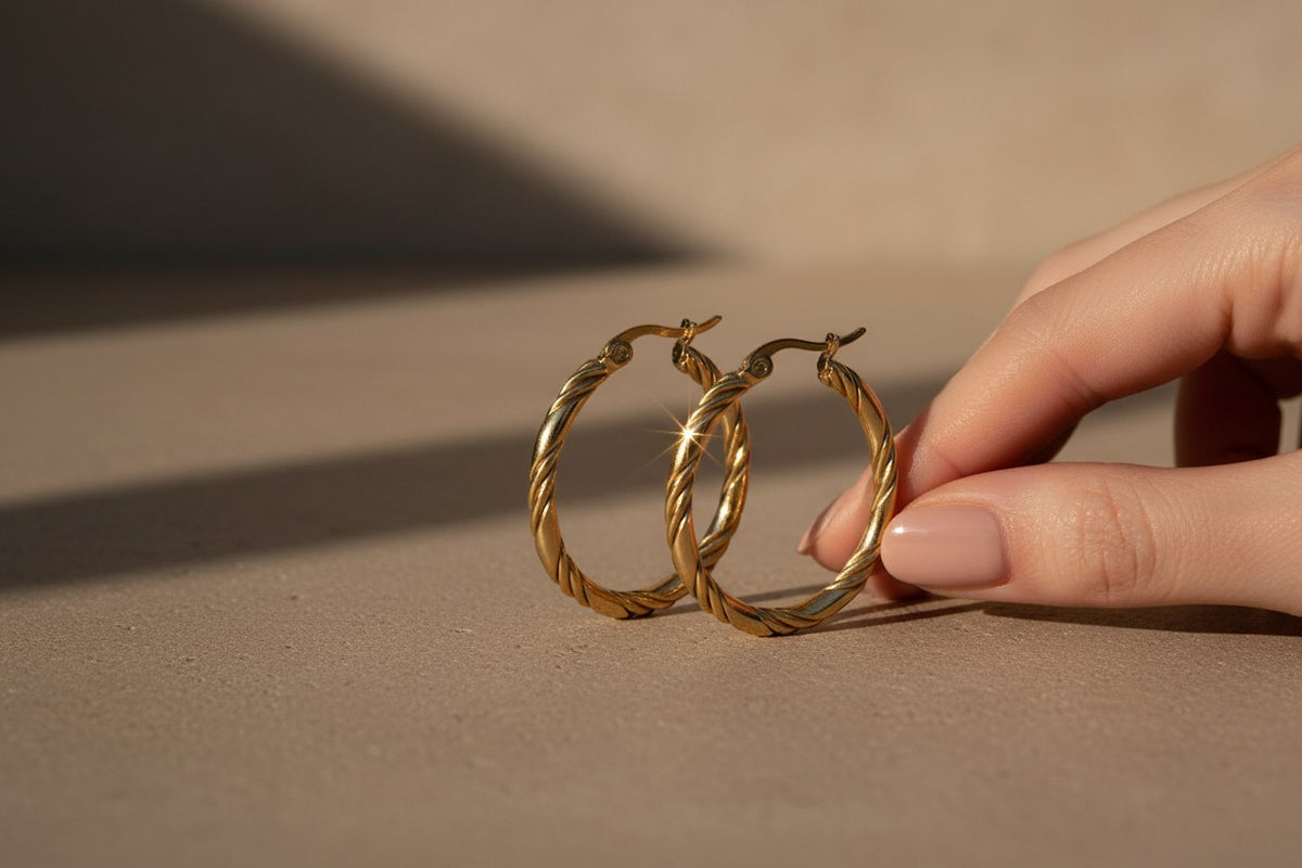 Aramat Jewels gold-tone stainless steel twisted hoop earrings, 30mm diameter, with a hinge closure.