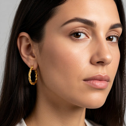 Aramat Jewels gold-colored twisted stainless steel hoop earrings, 30mm diameter, with a hinged closure.