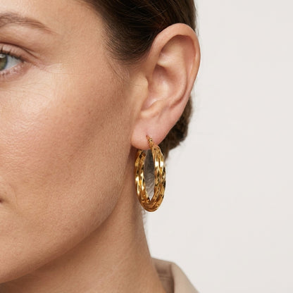 Aramat Jewels gold-tone twisted triple hoop earrings, 30mm diameter, made of stainless steel with gold plating.