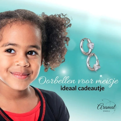 Aramat Jewels silver-tone hoop earrings with heart-shaped cubic zirconia, shown on a young girl.