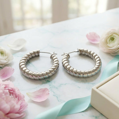 Aramat Jewels silver-colored hollow steel hoop earrings with a ribbed stripe motif, 30mm diameter.