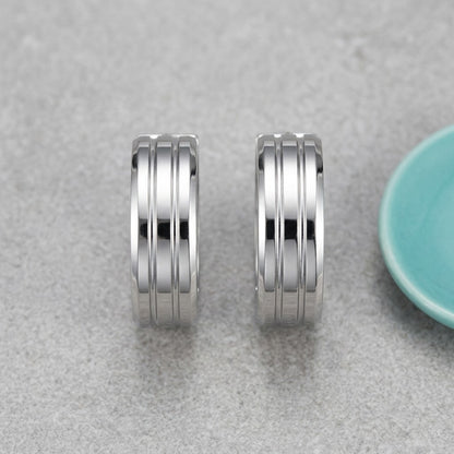 Aramat Jewels silver-tone stainless steel hoop earrings with three raised vertical stripes, 20mm diameter.