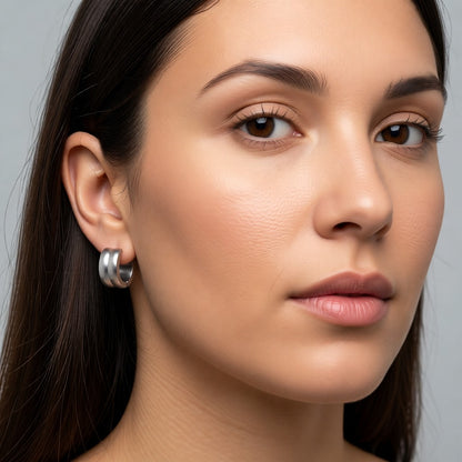 Aramat Jewels silver-tone stainless steel huggie hoop earrings with double stripe detail, 13mm diameter.