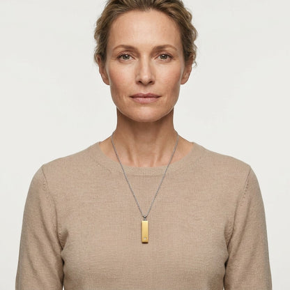 Aramat Jewels staaf ashanger van 4cm in goudkleurig roestvrij staal met een zirkonia, gedragen door een model.