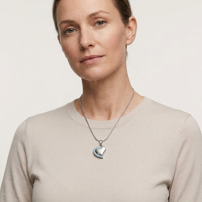 Aramat Jewels® zilverkleurige stalen hartvormige ashanger met zirkonia, gedragen door een vrouw.