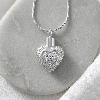 Aramat Jewels zilverkleurige hartvormige ashanger met ruitjesrand en transparante zirkonia steentjes.