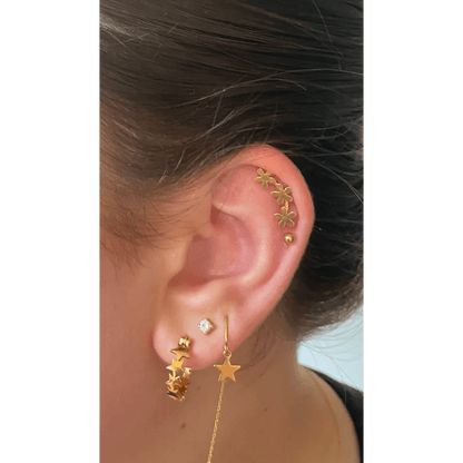 Een vrouw met een gouden oorpiercing