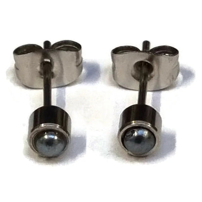 Een paar zilveren oorbellen met een zwarte steen