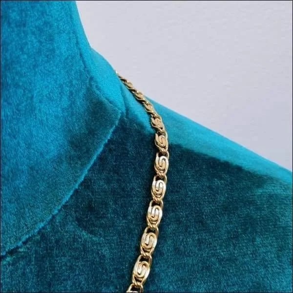 Een close-up van een gouden ketting op een blauw shirt