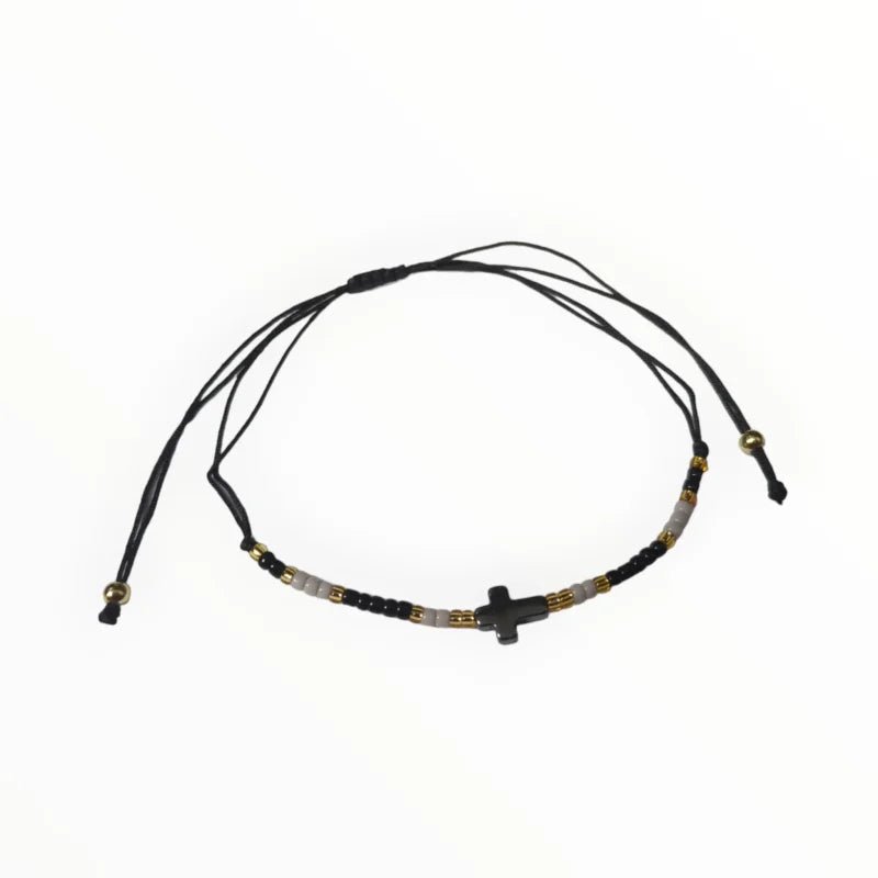 Een zwart met gouden armband met een zwart koord