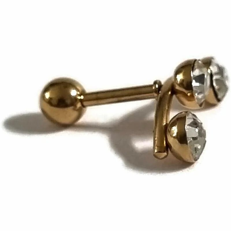 Een paar gouden en heldere kristallen oorbellen