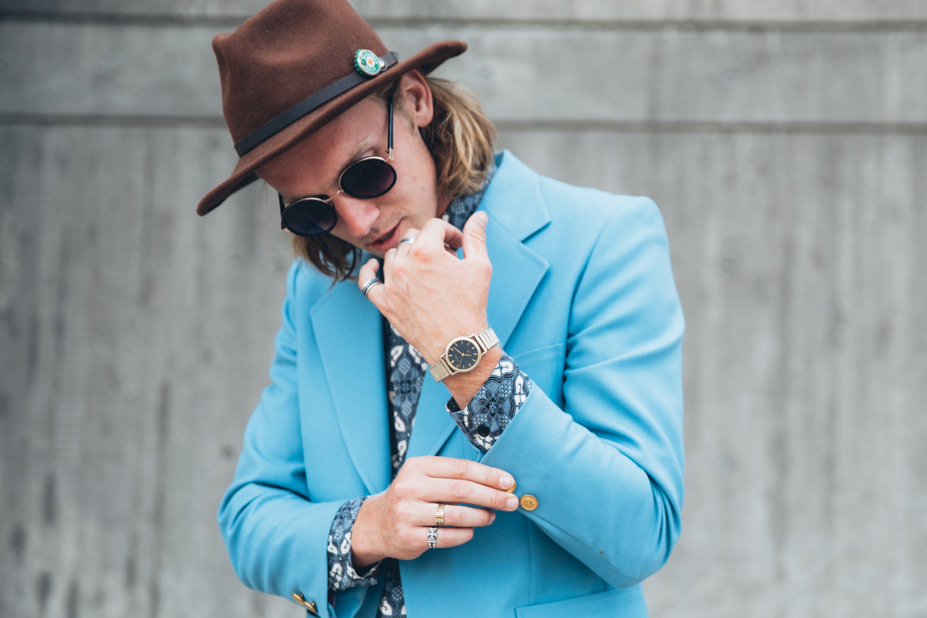 man met blauw colbert met ring en oorbellen