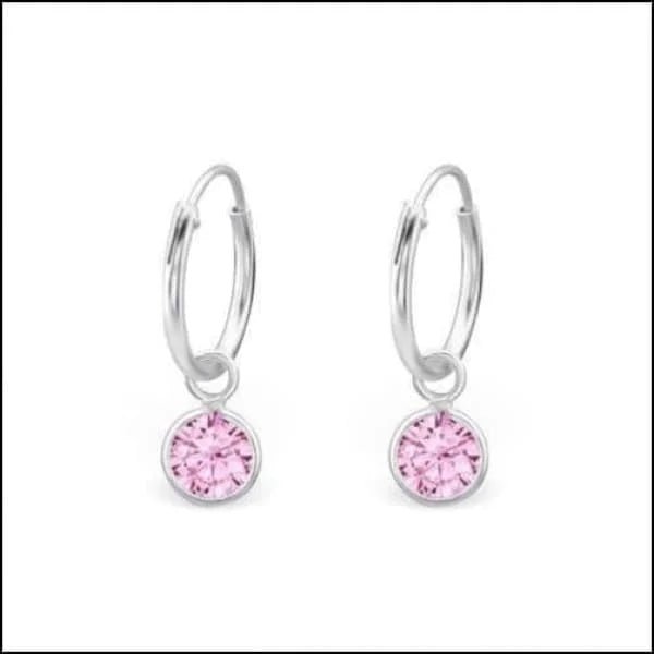 Een paar roze kristallen oorbellen met zilveren hoepels