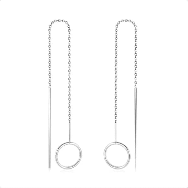 Een paar zilveren oorbellen met een cirkelvormig ontwerp