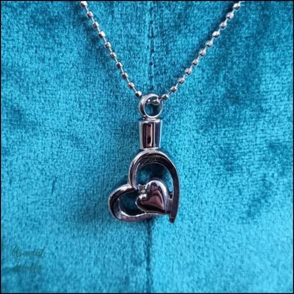 Een zilveren hart hanger op een blauw fluweel