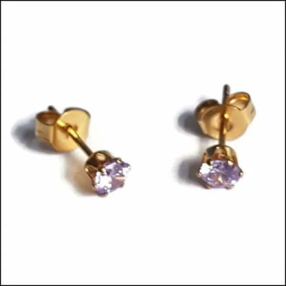 Een paar gouden oorbellen met een paarse steen