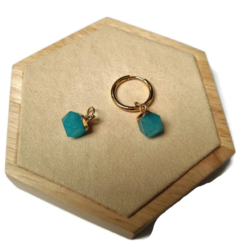 Een paar turquoise groene glazen oorbellen op een houten doosje