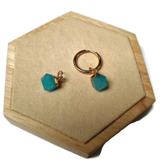 Een paar turquoise groene glazen oorbellen op een houten doosje