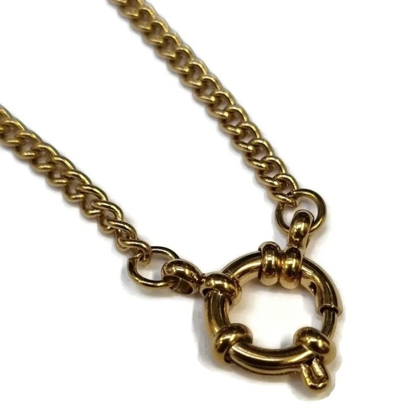 Een gouden halsketting met een ronde sluiting