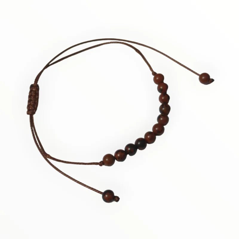 Een armband met houten kralen en een bruin koord