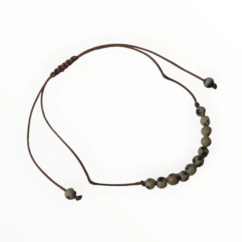 Een armband met een bruin koord en een bea