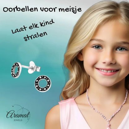 Zilveren cirkel oorbellen met zwarte accenten.