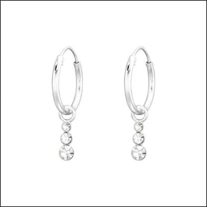 Een paar zilveren hoepel oorbellen met een enkele kristallen steen