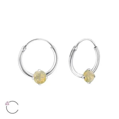 Een paar zilveren hoepeloorbellen met gele kristallen