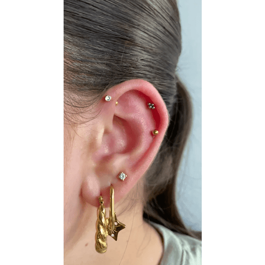 Een vrouw met een gouden oorpiercing